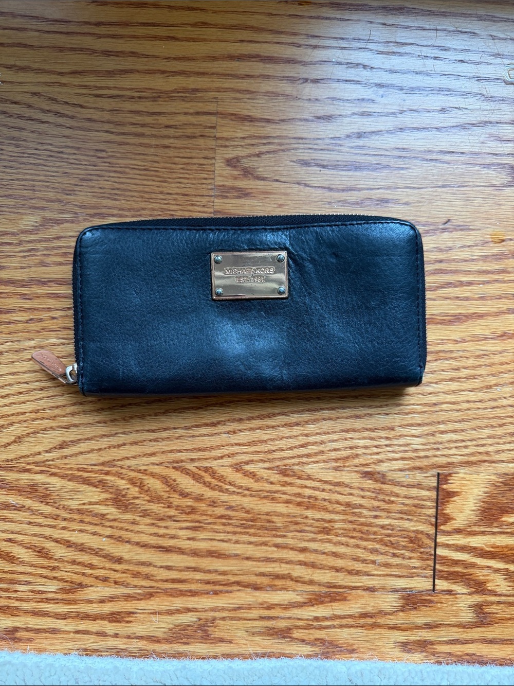 Michael Kors Black Leather Zip Wallet with rose gold color accents.